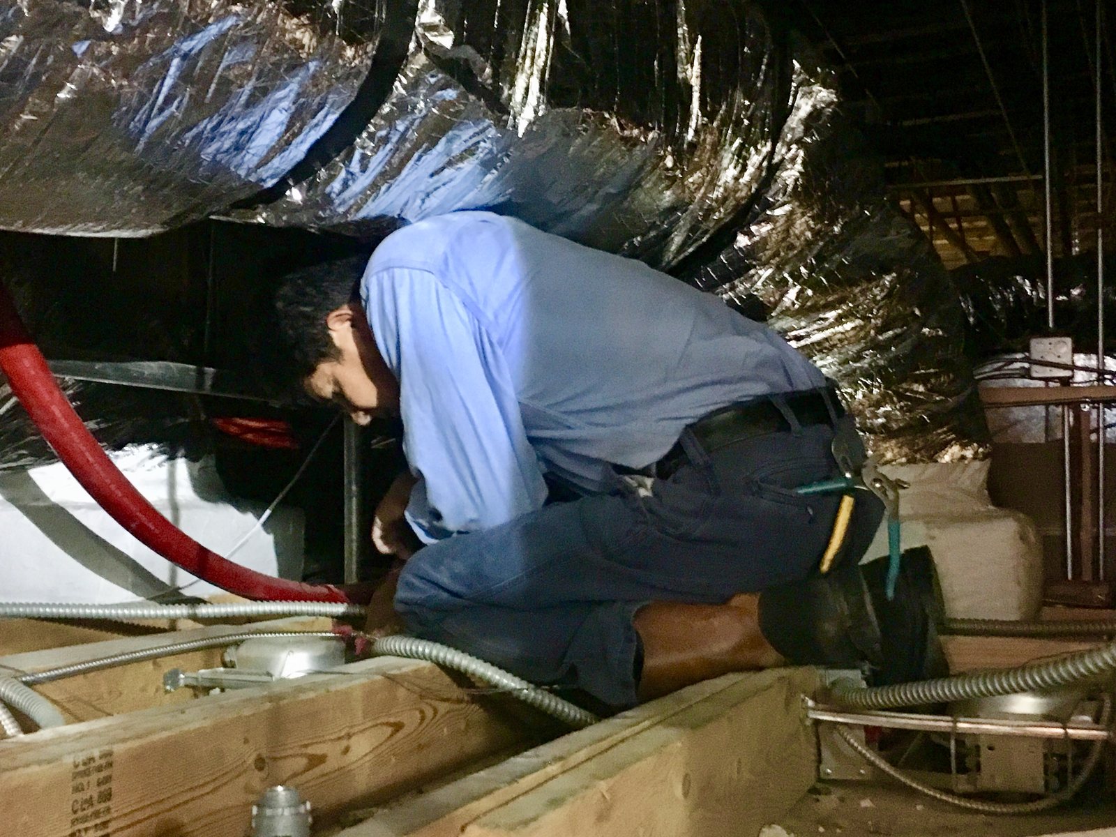 Charleston Electrical Services technician servicing wiring in a crawlspace